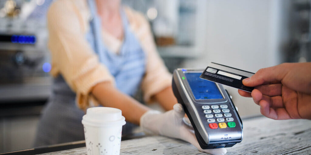 Contactless payment with debit card, coffee shop open after lockdown. Midsection.