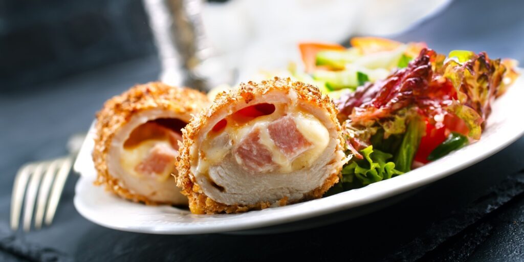 meat cutlet cordon bleu, cutlet with fresh salad on plate
