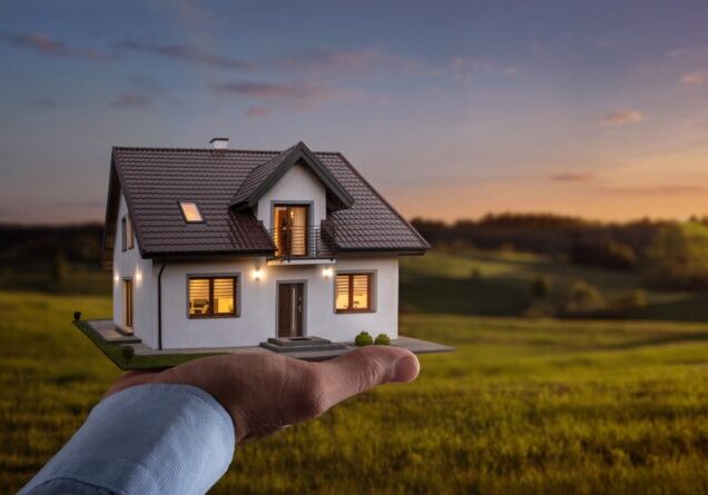 Concept of buying or building new home. Male hand showing, offering a new dream house at the empty field with copy space