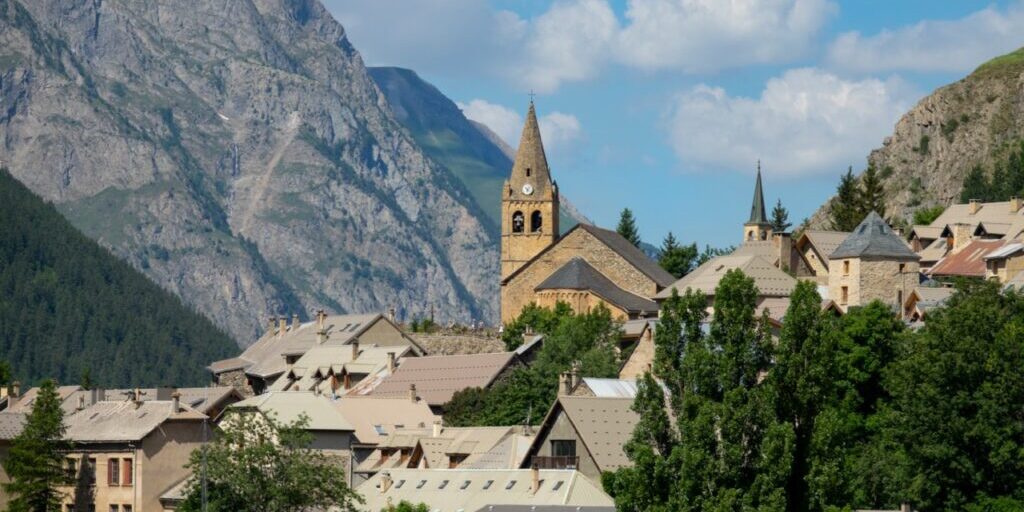 CLOSE UP: Old church towers above the small ski town in breathtaking French Alps