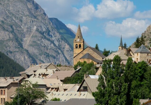 CLOSE UP: Old church towers above the small ski town in breathtaking French Alps