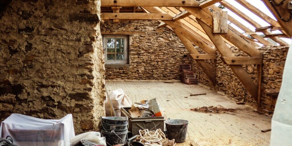 Old typical stone wall house undergoing a roof renovation - French countryside