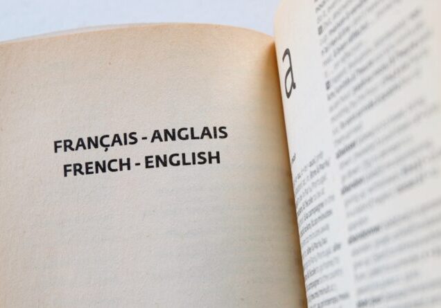 Inside pages of a French-English pocket dictionary. Concept for studying a second language, learning a foreign culture, breaking communication barrier, improving brain function, developing new skills.