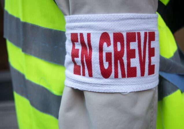 Closeup of man protesting in the street with cut and text in french : en greve, traduction in english : striking